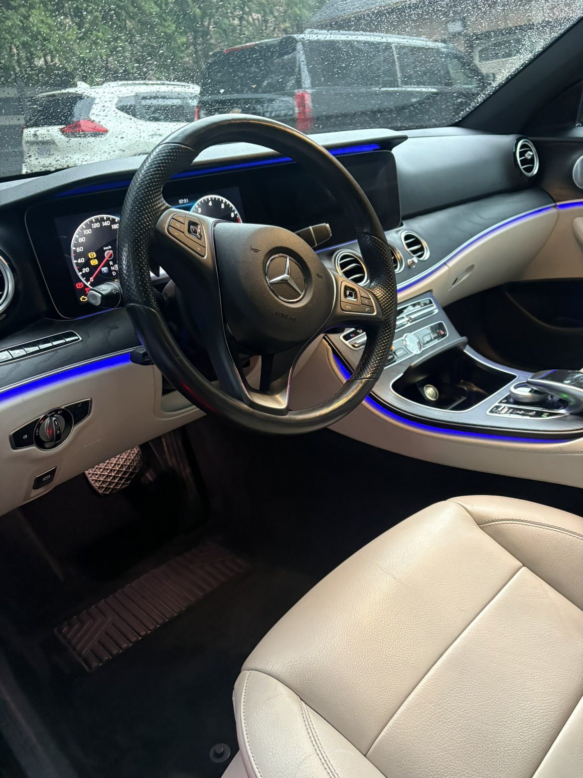 Mercedes-Benz E-Class interior with cream leather and blue ambient lighting after detailing