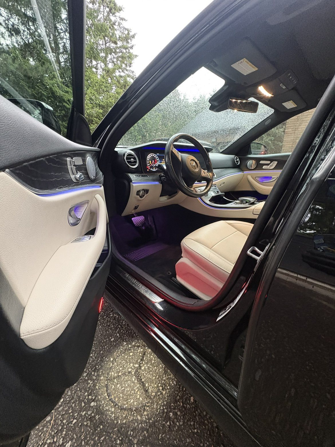 Mercedes-Benz E-Class with door open showing detailed cream interior