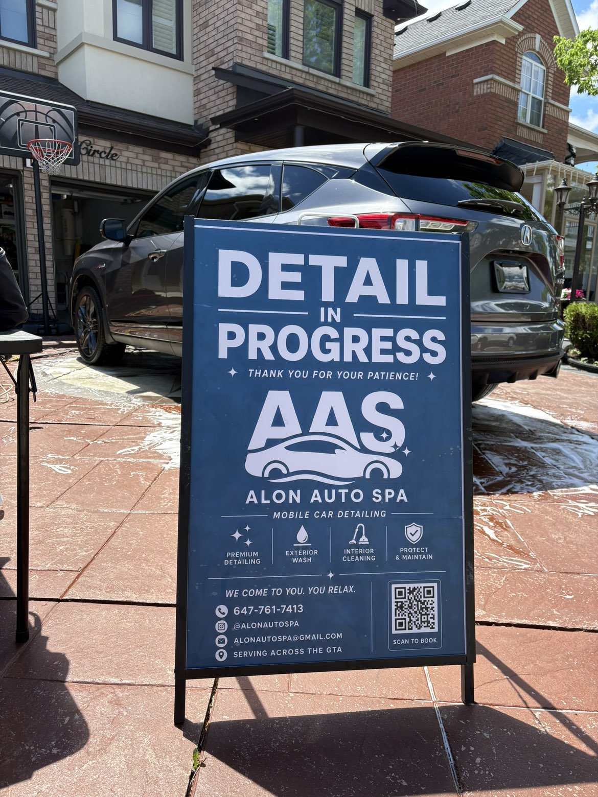 Alon Auto Spa detail in progress — SUV being washed, suds on the driveway