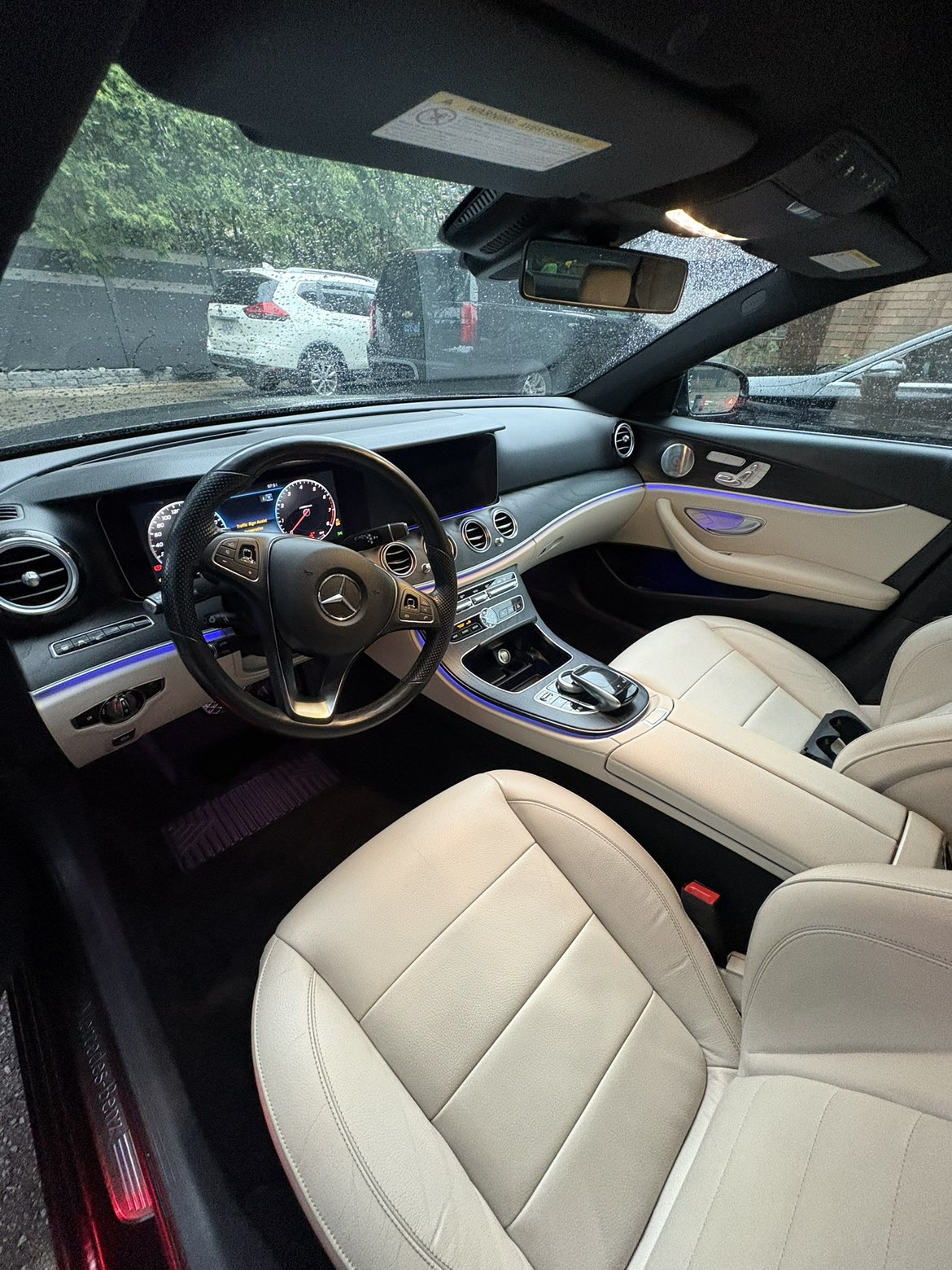Mercedes-Benz E-Class interior with cream leather and blue ambient lighting