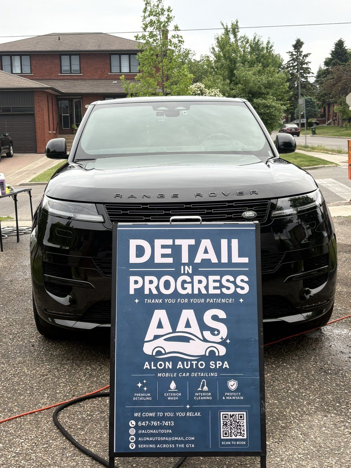 Range Rover front end gleaming beside the Alon Auto Spa sign