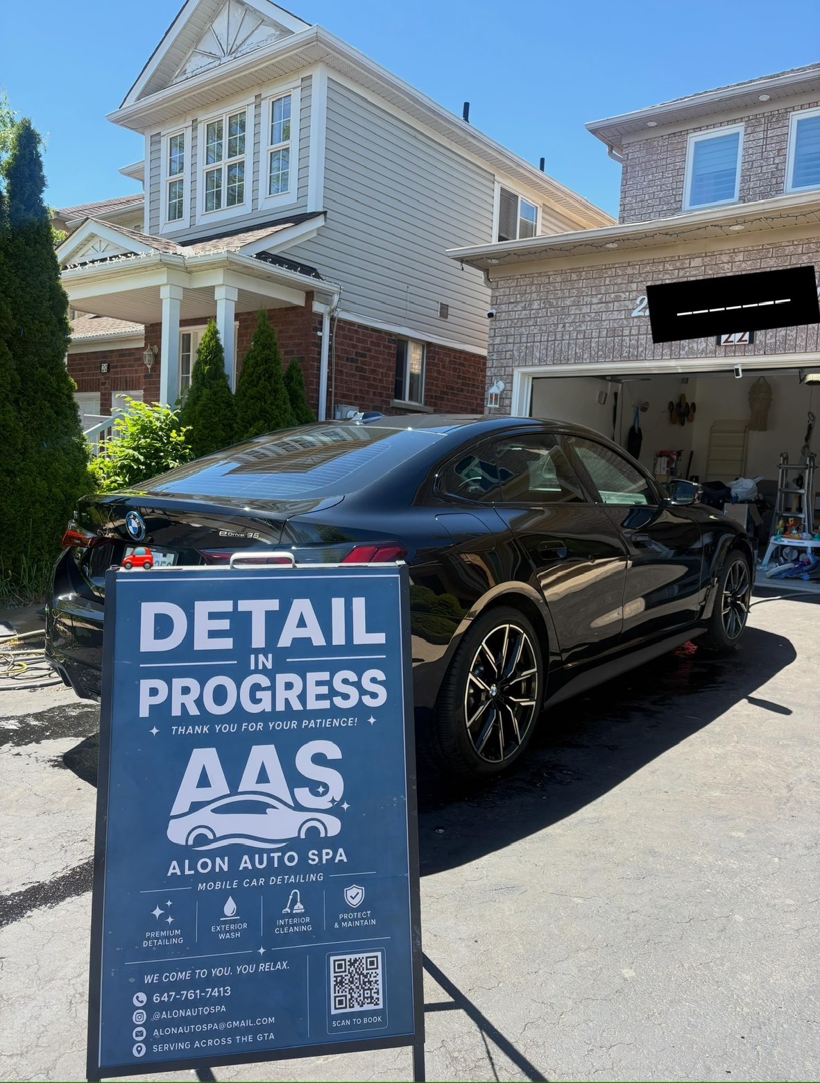 Black BMW i4 rear with the Alon Auto Spa sign after a complete detail