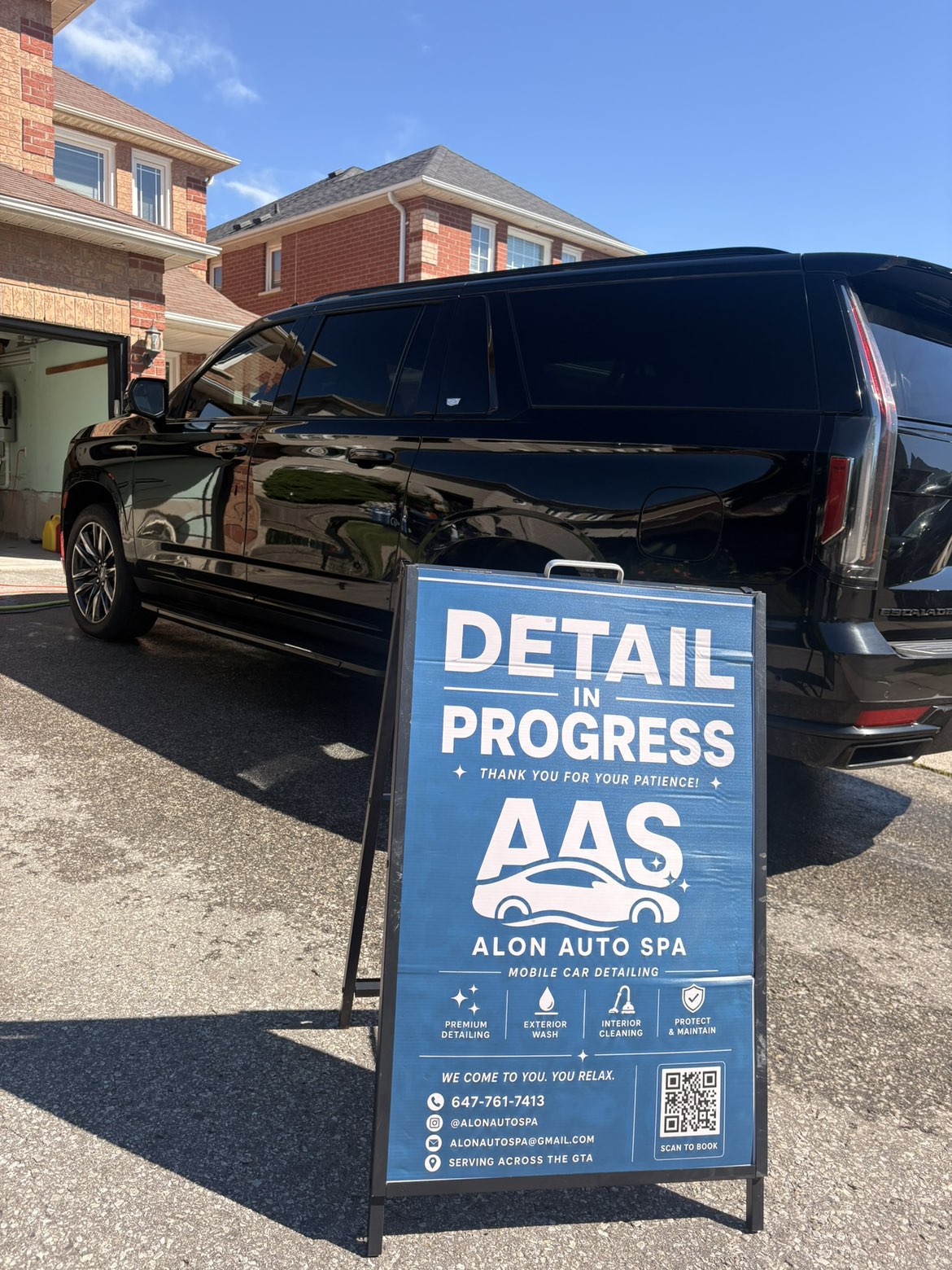 Black Cadillac Escalade mid-detail with the Alon Auto Spa sign